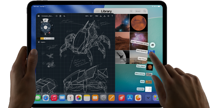 iPad Pro i space black, brugerens venstre hånd holder enheden, mens højre hånd interagerer med forskellige åbne appvinduer, en tegneapp med skitser af mekaniske design, et billedbibliotek med billeder af planeter og rummet, filer i downloadmappen spredt i en vifte